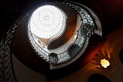 Fotokunst: Licht und Schatten im Treppenhaus mit kunstvollem Geländer