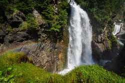 Dolomiten Wandbild: Wasserfall mit Regenbogen, sanfte Farben in der Natur