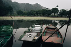 Calm boat scenery in Ninh Binh, Vietnam, featuring mountains and tranquil water.