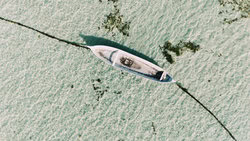 Wandbild: Einsames Boot auf ruhigem Wasser in Bali, Indonesien.