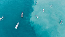 Photo art by Christian Seidenberg: boats on deep blue ocean with choppy water