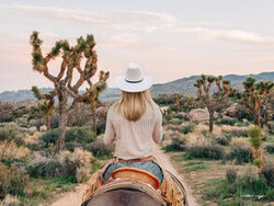 Fotokunst einer Cowgirl im Wüstenumfeld mit Kakteen und weiten Landschaften