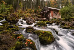 Photo art by Achim Thomae: historic watermill in the woods with autumn colors.