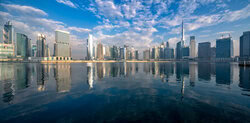 Wall art by Achim Thomae: clear skyline of Business Bay with water reflection