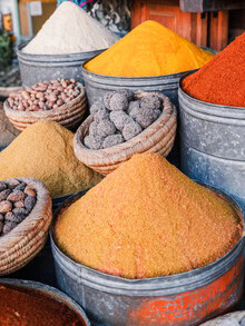Colorful spices at a Moroccan market, warm light and inviting atmosphere.