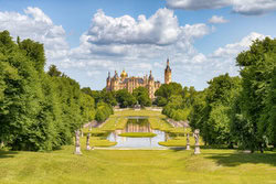 Schwerin Castle with gardens, soft colors and calm reflection in the water.