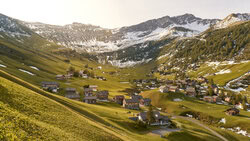 Sonnenaufgang über Malbun, Liechtenstein mit warmem Licht auf den Bergen.