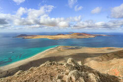 View from Lanzarote to La Graciosa: cliffs and Atlantic Ocean under clear skies.
