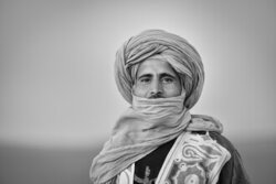 Fotokunst aus Marokko: Porträt eines Amazigh mit traditionellem Turban in der Wüste.