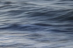 Photo art: gentle wave movement at the coast, calming shades of blue