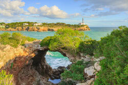 Stone arch in Portocolom, Mallorca: tranquil coastal landscape with clear blue water