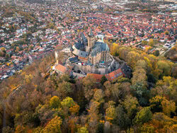 Aerial view of Wernigerode Castle in autumn, surrounded by colorful leaves.