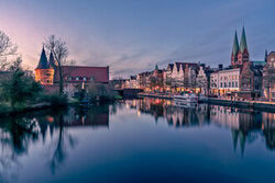 Photo art by Achim Thomae: city view of Lübeck at sunset featuring the Holstentor