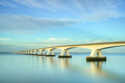 Photo art by Michael Valjak: Zeeland Bridge at dusk reflecting on calm waters