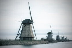 Fotokunst von Oliver Buchmann: Mühlen von Kinderdijk unter einem bewölkten Himmel