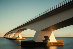 Photo art by Oliver Buchmann: elegant Zeeland bridge over water during golden hour