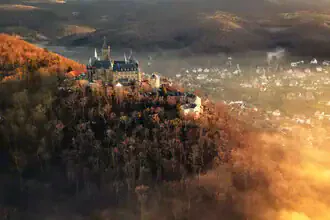 Wernigerode Castle in soft evening light, surrounded by autumn fog