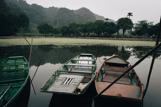 Calm boat scenery in Ninh Binh, Vietnam, featuring mountains and tranquil water.