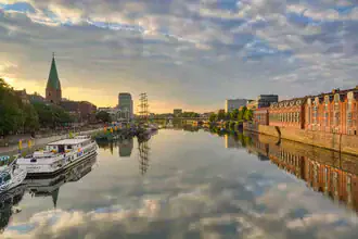 View across the Weser in Bremen: gentle morning light reflecting on the city and water.