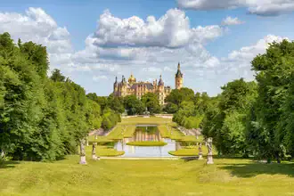 Schwerin Castle with gardens, soft colors and calm reflection in the water.