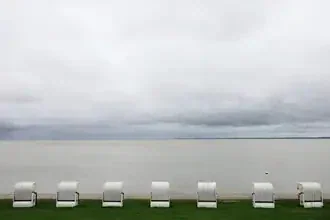 Waiting for summer: beach chairs by the sea under a cloudy sky