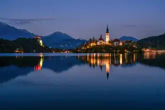 Sunset at Lake Bled in Slovenia with reflecting water and gentle hills