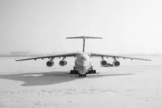 Fotokunst von Inflight Galerie: Antonov An125 über schneebedecktem Terrain in Schwarz-Weiß.