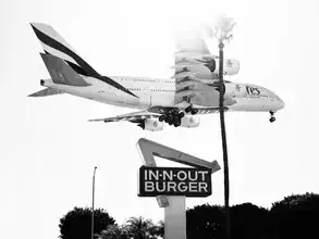 Fotokunst von Inflight Galerie: Emirates A380 landet über palmengesäumtem Strand in Los Angeles.