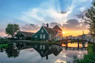 Sunrise over Zaanse Schans with calm water surface and reflections