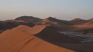 Photo art by Dennis Wehrmann: peaceful sunrise in the Sahara with gentle dunes.
