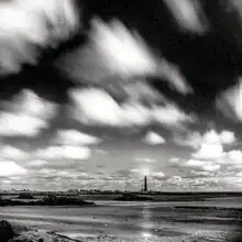 Fotokunst von J. Daniel Hunger: Leuchtturm unter dem Vollmondhimmel in der Bretagne