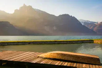 Fotokunst von Martin Wasilewski: friedliche Morgenstimmung am See mit Bergen im Hintergrund