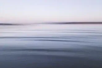 Malerische Küstenabstraktion bei Dämmerung mit sanften Wellenbewegungen