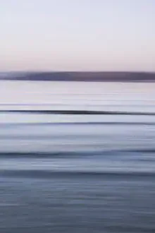 Malerische Küstenabstraktion bei Dämmerung, sanfte Wellenbewegungen und ruhige Stimmung