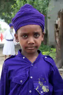 Porträt eines Jungen mit unschuldigen Augen in einer lebhaften Straßenszene in Indien.
