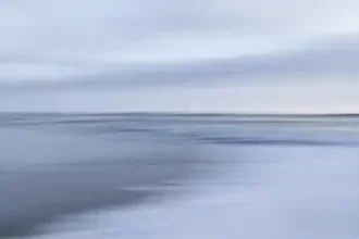 Blurred winter shoreline with soft hues and minimalist composition