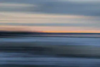 Verwischter Wintersonnenuntergang über dem Holnis Noor, sanfte Farben und Bewegung.