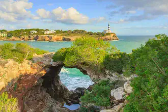 Stone arch in Portocolom, Mallorca: tranquil coastal landscape with clear blue water