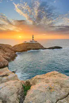 Sunrise at Faro de Cala Figuera in Mallorca with calm sea and clear sky