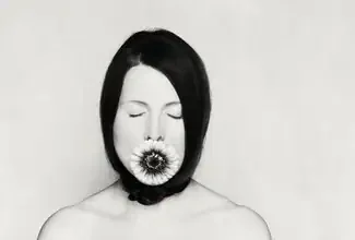 Photo art by Manuela Deigert: Woman with blooming Gerbera flowers in soft tones.