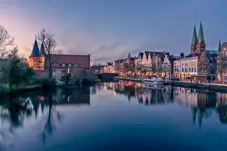 Photo art by Achim Thomae: city view of Lübeck at sunset featuring the Holstentor