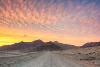 Straße zum Punta de Jandía auf Fuerteventura, sanfte Hügel und Sonnenuntergangsstimmung