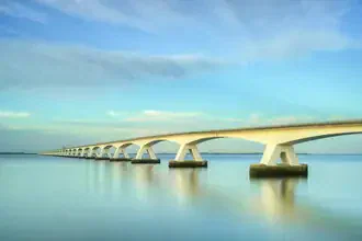 Photo art by Michael Valjak: Zeeland Bridge at dusk reflecting on calm waters