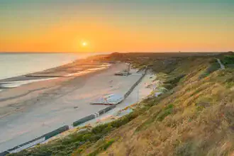 Wunderschöne Abendstimmung am Strand von Zoutelande mit sanften Wellen und warmen Farben.