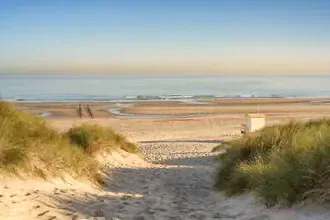 Weg zum Strand in Walcheren: sanfte Dünenlandschaft und strahlender Himmel