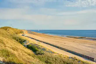 Blick über den Strand von Zoutelande mit sanften Dünen und ruhigem Meer