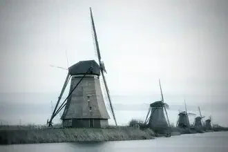 Fotokunst von Oliver Buchmann: Mühlen von Kinderdijk unter einem bewölkten Himmel