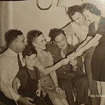 Cpl. Harold Beggs visiting his family from a military hospital. From the left: His father, Leo, his brother, David, his mother, Lydia, and Harold. Standing, his sister, Mildred Taylor, and her husband, George Taylor. It appears they were looking at one of his medals. - Courtesy of Vicky Taylor BeggsHH1