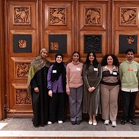 Diverse group celebrates community engagement against a stunning wooden backdrop.