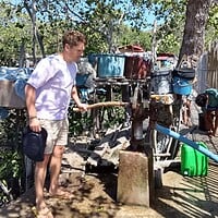 Visitors engaging with local water infrastructure in a rural Filipino setting. Exploring local water sources and traditional water pumps in the Philippines.